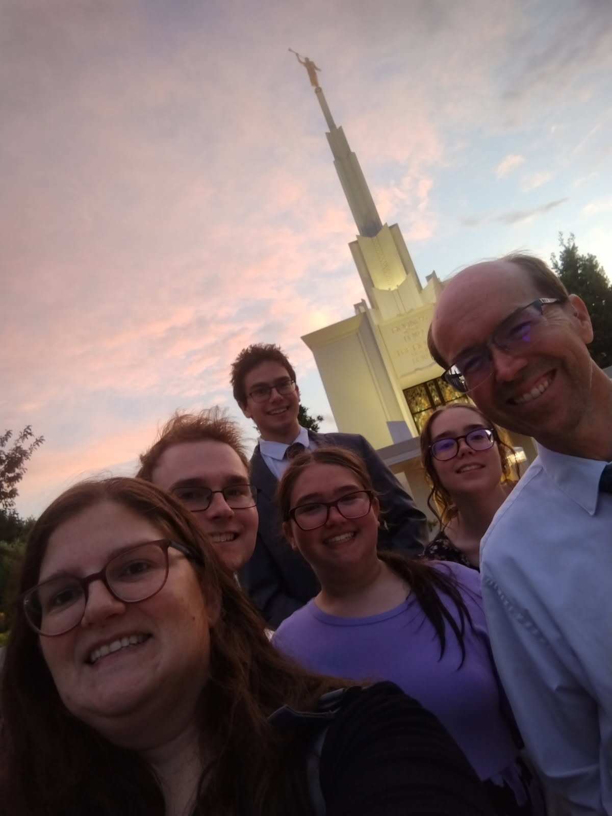 Mom taking a selfie with the family at the temple at sunset